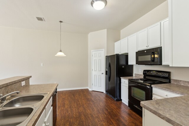 kitchen with dark wood-style floors, a sink, black appliances, white cabinetry, and hanging light fixtures