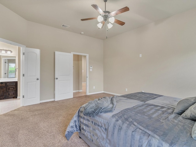 carpeted bedroom with a ceiling fan, baseboards, visible vents, and ensuite bath
