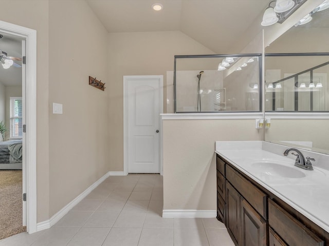 ensuite bathroom with vanity, baseboards, tile patterned floors, lofted ceiling, and ensuite bath