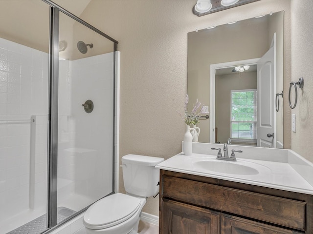 full bathroom with vanity, toilet, a textured wall, and a stall shower