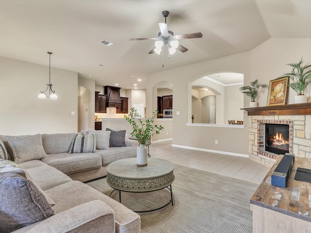living area with a fireplace and a ceiling fan