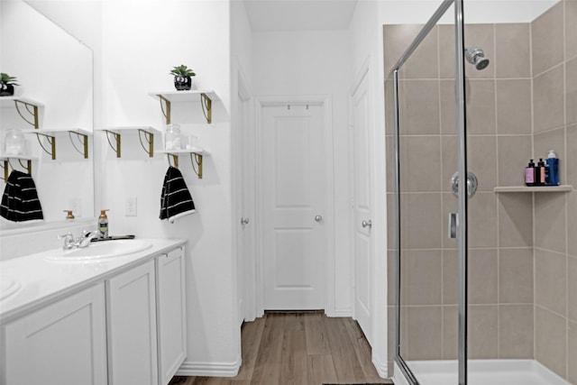 full bathroom with a shower stall, wood finished floors, and vanity