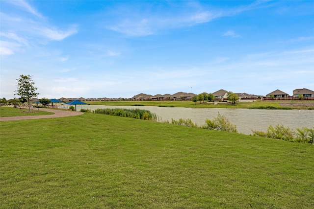 view of yard featuring a residential view and a water view