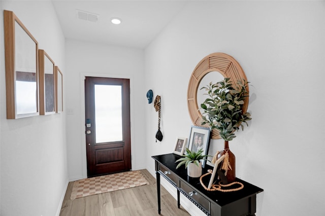 doorway to outside featuring baseboards, wood finished floors, and visible vents