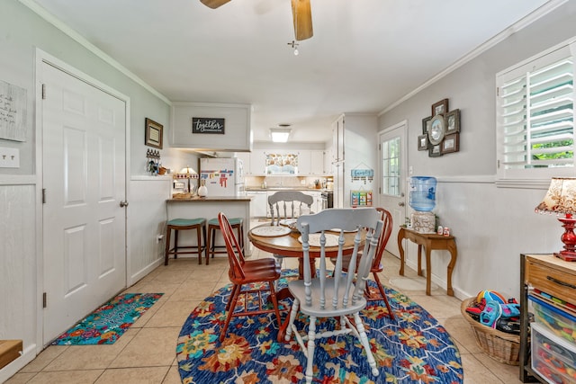 dining space featuring light tile patterned floors, crown molding, and ceiling fan