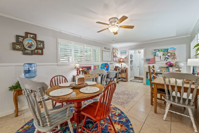 dining space featuring crown molding, ceiling fan, and light tile patterned floors