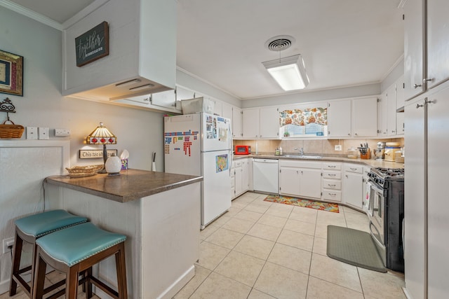kitchen with crown molding, white cabinets, a sink, appliances with stainless steel finishes, and light tile patterned floors