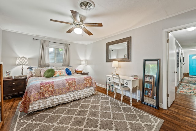 bedroom with visible vents, ornamental molding, baseboards, and wood finished floors