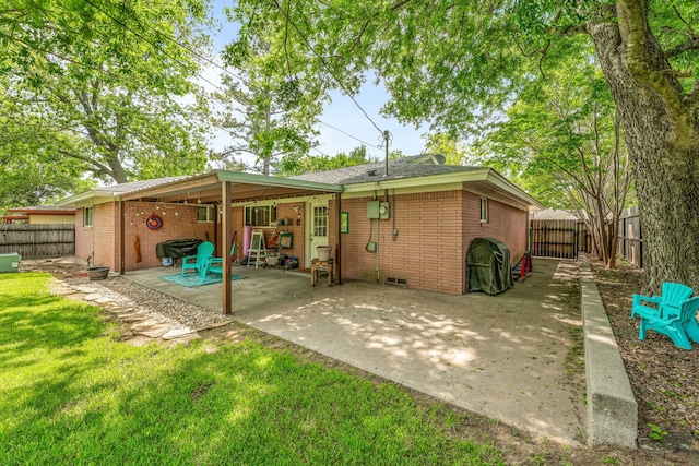rear view of property with brick siding, a patio, and a fenced backyard