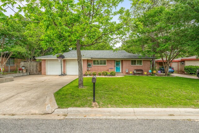 ranch-style house with brick siding, fence, a front lawn, concrete driveway, and an attached garage