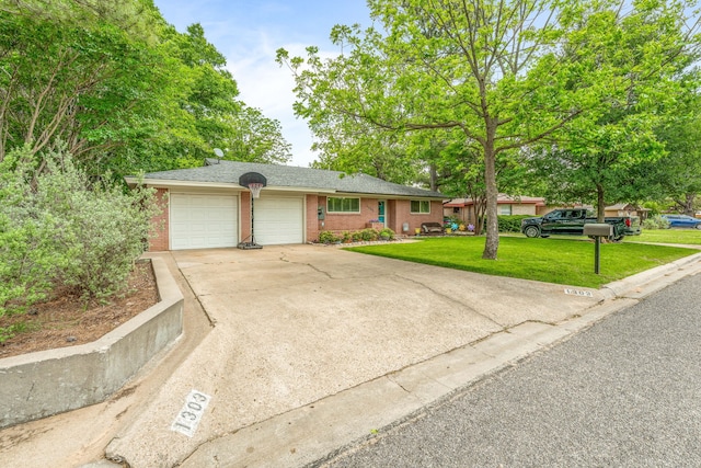 ranch-style home featuring a garage, concrete driveway, a front yard, and brick siding