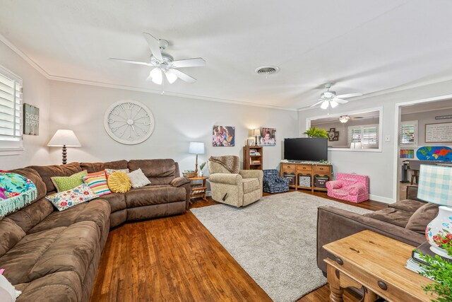 living room with a wealth of natural light, ceiling fan, wood finished floors, and visible vents
