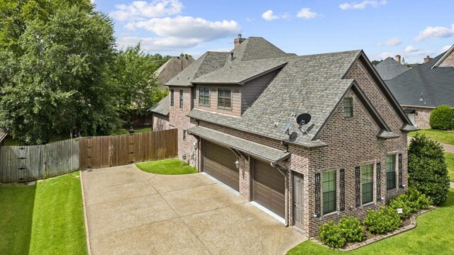 view of property exterior featuring concrete driveway, an attached garage, fence, and a shingled roof