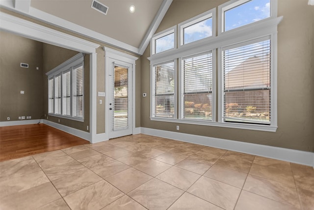 interior space featuring visible vents, baseboards, and high vaulted ceiling