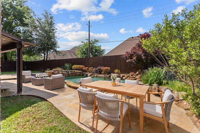 view of patio / terrace with a fenced in pool, a fenced backyard, outdoor dining space, and an outdoor hangout area