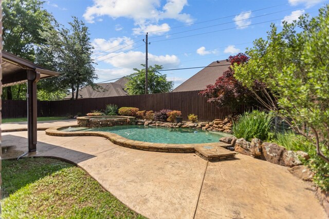 view of swimming pool featuring a patio, a pool with connected hot tub, and a fenced backyard