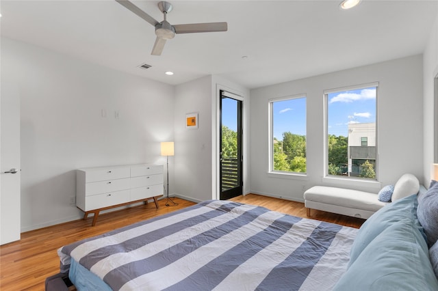 bedroom featuring wood finished floors, visible vents, access to outside, and baseboards