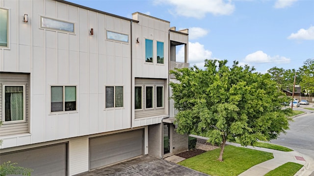 exterior space featuring driveway, an attached garage, and board and batten siding