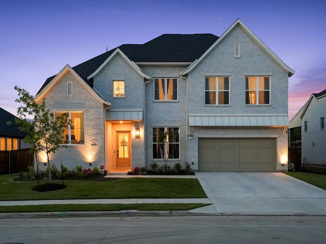 view of front of home with an attached garage, brick siding, driveway, and a front yard