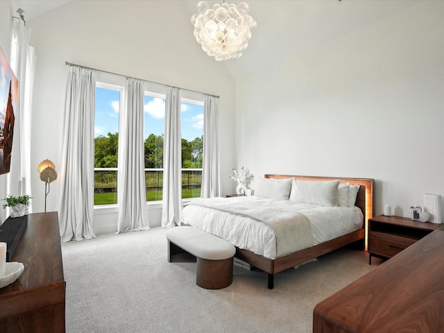 carpeted bedroom with an inviting chandelier and lofted ceiling