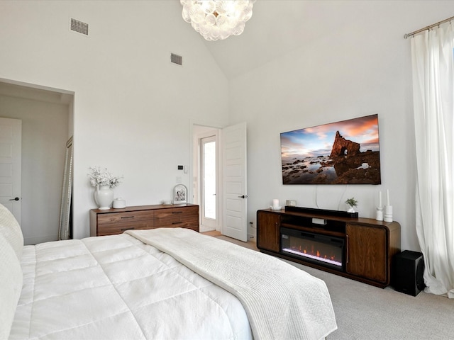 bedroom featuring high vaulted ceiling, a chandelier, carpet floors, and visible vents