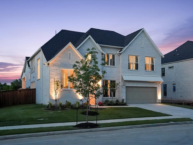 view of front facade with a yard, an attached garage, fence, and driveway