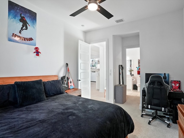 carpeted bedroom with visible vents, a ceiling fan, and ensuite bath