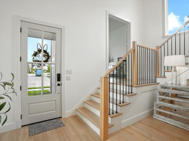 entrance foyer featuring plenty of natural light, stairs, and wood finished floors