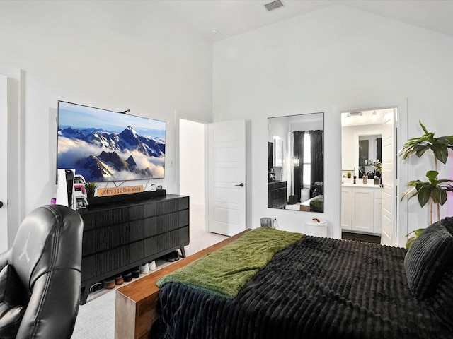bedroom featuring connected bathroom and high vaulted ceiling