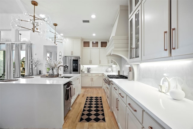 kitchen with stainless steel appliances, recessed lighting, a sink, and light wood-style floors