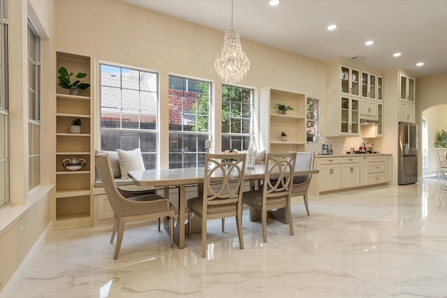 dining area featuring recessed lighting, marble finish floor, a notable chandelier, and arched walkways
