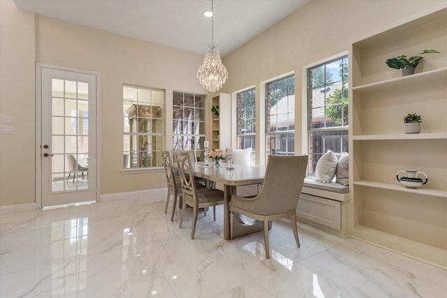 dining area with a chandelier, built in features, marble finish floor, and baseboards