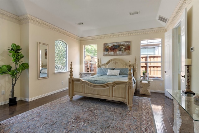 bedroom with dark wood-style flooring, visible vents, and multiple windows