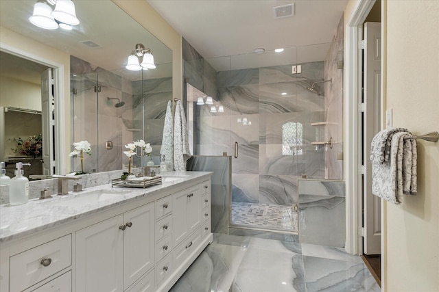 bathroom featuring double vanity, visible vents, a shower stall, and a sink