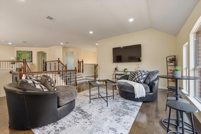 living area featuring recessed lighting, wood finished floors, arched walkways, visible vents, and lofted ceiling