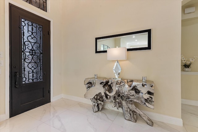 foyer entrance featuring marble finish floor and baseboards