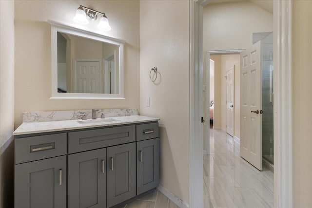 ensuite bathroom with marble finish floor, baseboards, vanity, and ensuite bathroom