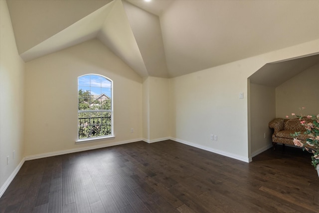 additional living space with dark wood-style floors, baseboards, and lofted ceiling