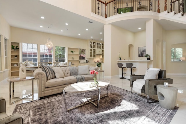 living area with baseboards, recessed lighting, a healthy amount of sunlight, and a towering ceiling