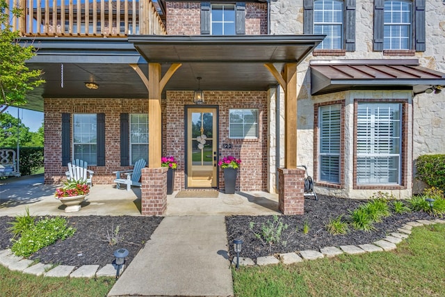 122 Forest Hills Cir, Gunter, TX 75058 - view of exterior entry with a standing seam roof, a porch, a balcony, and brick siding
