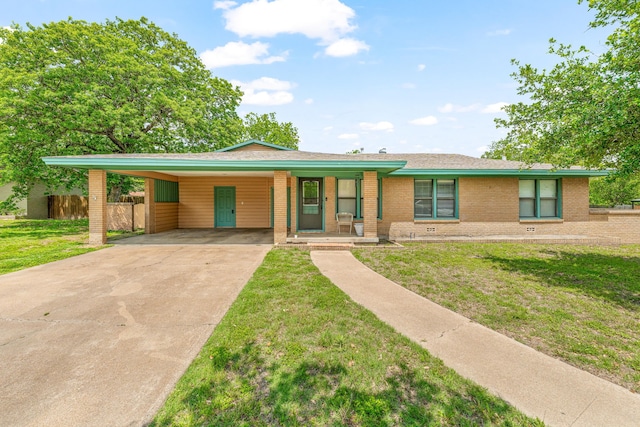 view of front of home featuring a front yard, a carport, brick siding, fence, and concrete driveway
