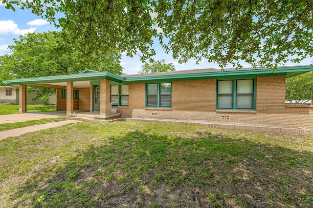 ranch-style home with brick siding, a front lawn, driveway, and a carport
