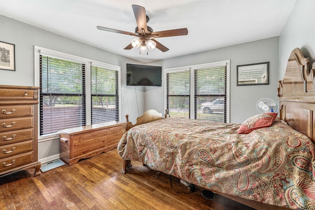 bedroom with a ceiling fan, multiple windows, and wood finished floors