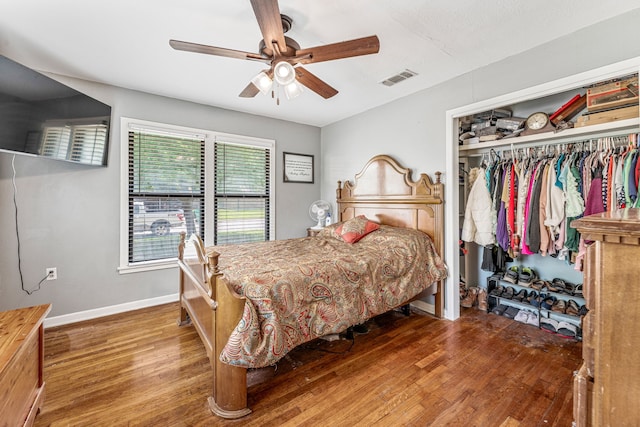 bedroom featuring ceiling fan, baseboards, wood finished floors, visible vents, and a closet
