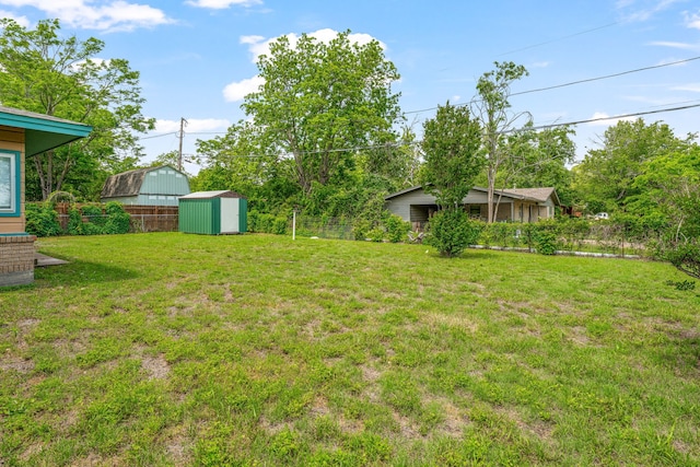 view of yard featuring fence, an outbuilding, and a storage unit