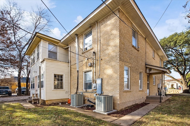 view of home's exterior with cooling unit and brick siding