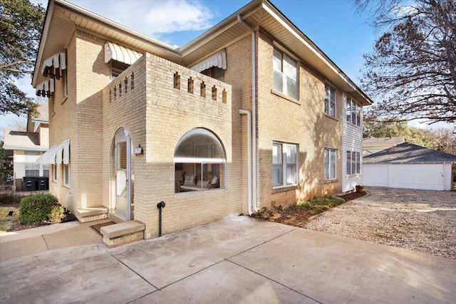 view of front of property featuring a patio and brick siding