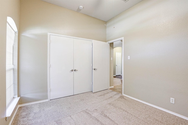 1108 Mourning Dove Dr, Burleson, TX 76028 - unfurnished bedroom featuring carpet flooring, arched walkways, multiple windows, and a closet