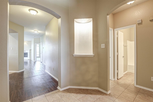 1108 Mourning Dove Dr, Burleson, TX 76028 - corridor featuring tile patterned flooring, arched walkways, and baseboards