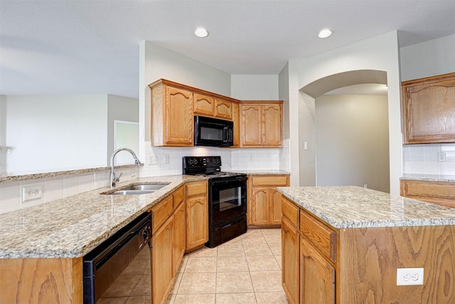 1108 Mourning Dove Dr, Burleson, TX 76028 - kitchen with light stone countertops, a sink, arched walkways, tasteful backsplash, and black appliances